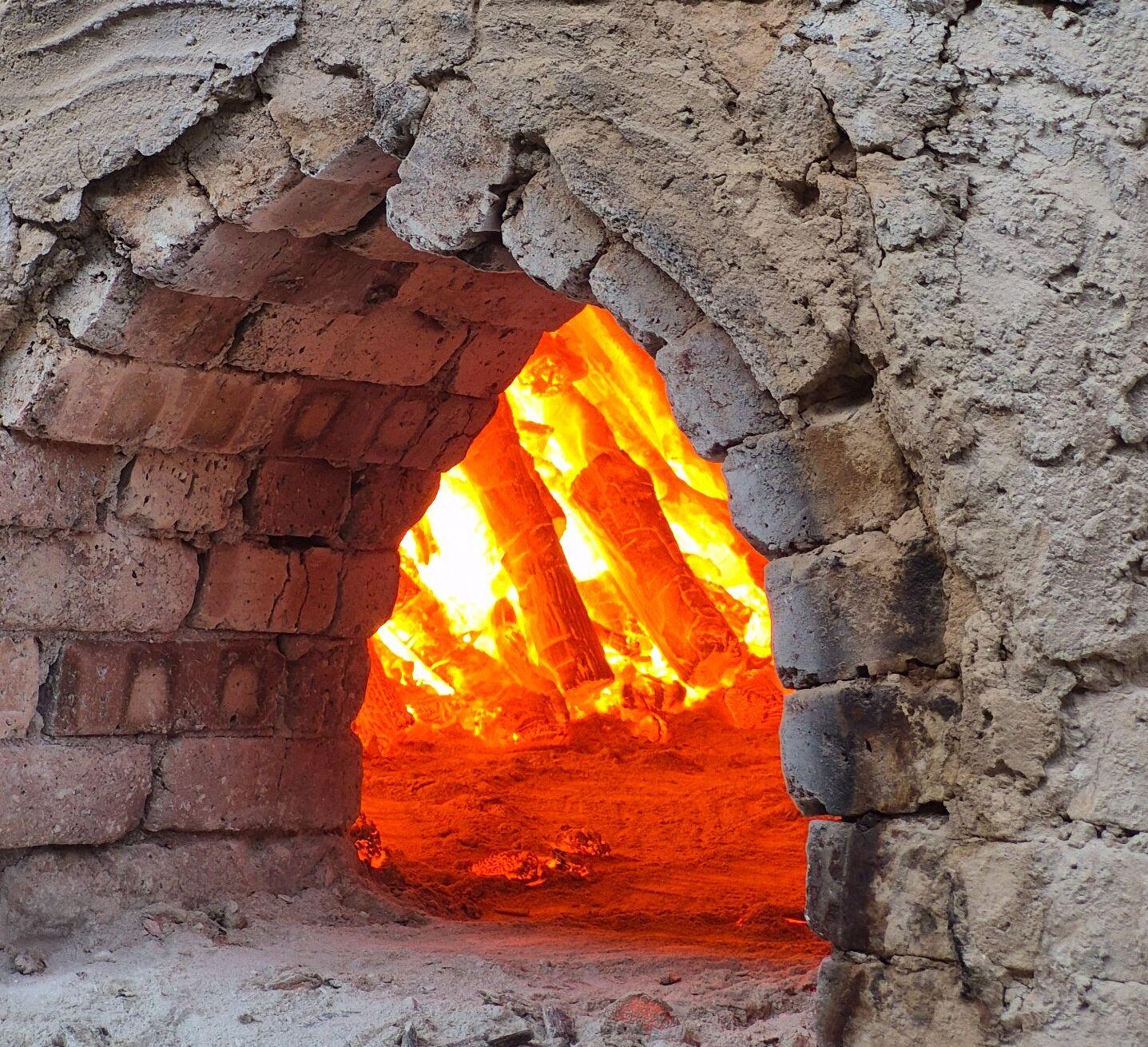 White Charcoal vs Black Charcoal: Why Is Binchotan Superior? 2 Binchotan production process - workers blowing air to make charcoal red-hot at 1000-1200°C